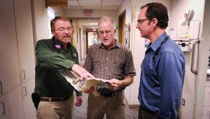 three doctors discussing a patient file a the Bozeman Clinic