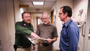 three doctors discussing a patient file a the Bozeman Clinic