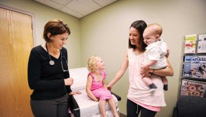 Dr. Christine Mitchell with a family in an exam room at Bozeman Clinic in Bozeman, MT