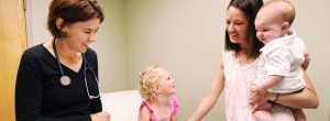 Dr. Christine Mitchell with a family in an exam room at Bozeman Clinic in Bozeman, MT